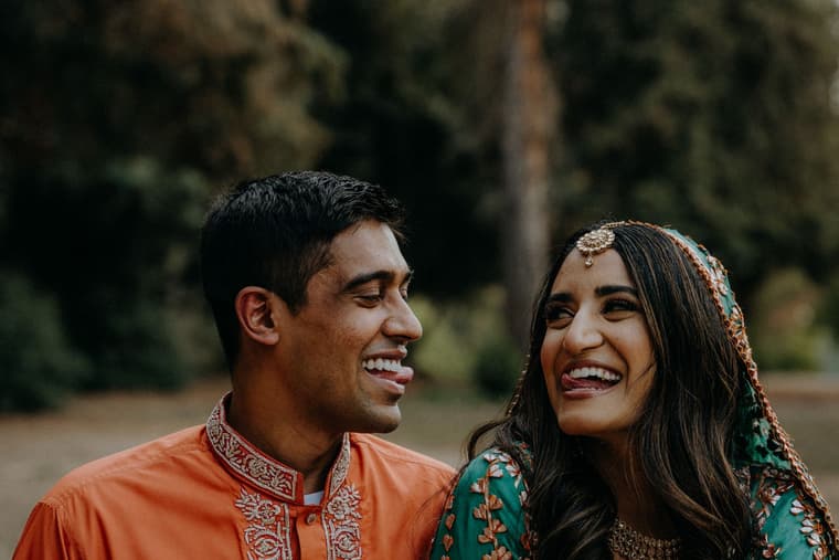 A couple laughing together outdoors.